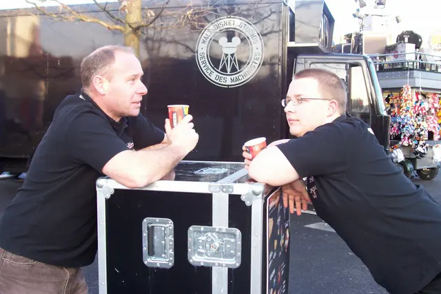 Colin and Darren chatting over a flight case with a cuppa at Disneyland Paris