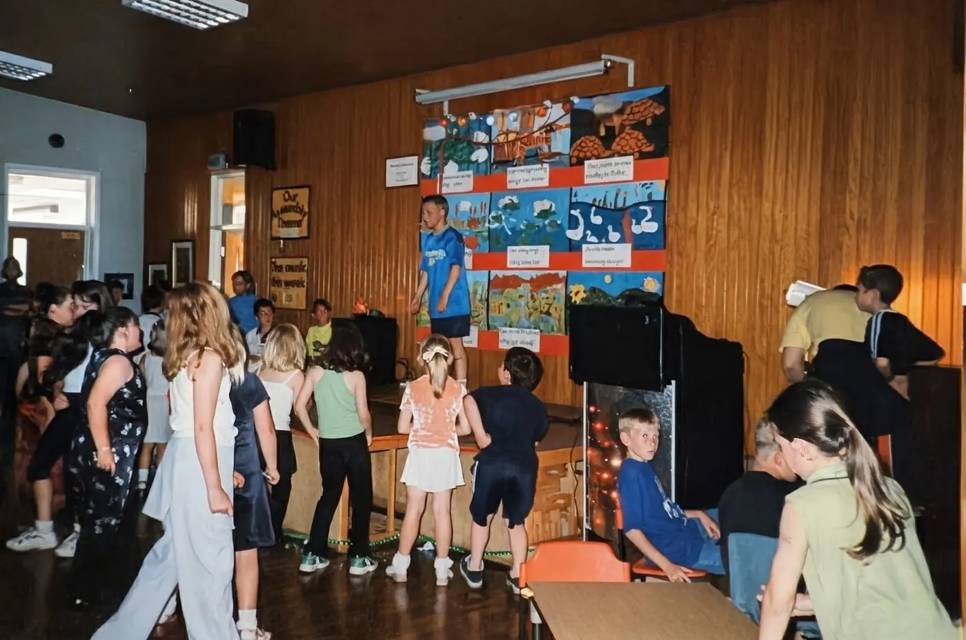 The Black Box Boys' first ever gig: a school hall disco with children dancing, a speaker stack and fairy lights