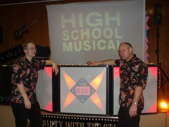 Darren and Colin either side of the BBB disco booth with High School Musical on the big screen