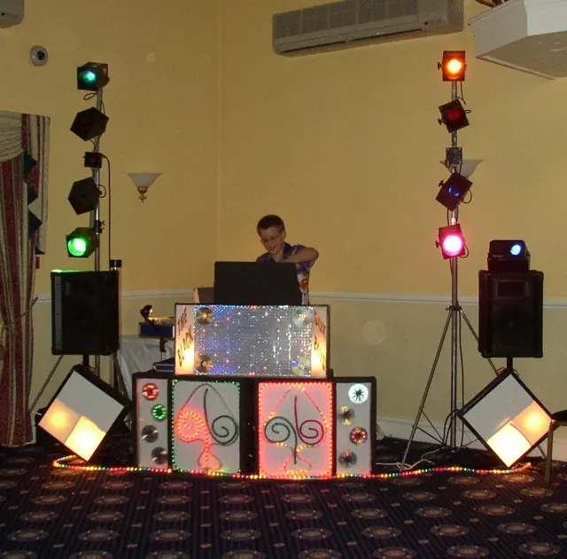 A Black Box Boys disco setup with a sparkly booth and two towers of coloured lights