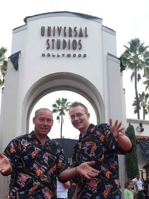 Colin and Darren in matching patterned shirts under the Universal Studios Hollywood arch